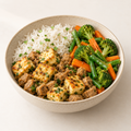 Paneer and soya protein bowl with rice and cooked vegetables.